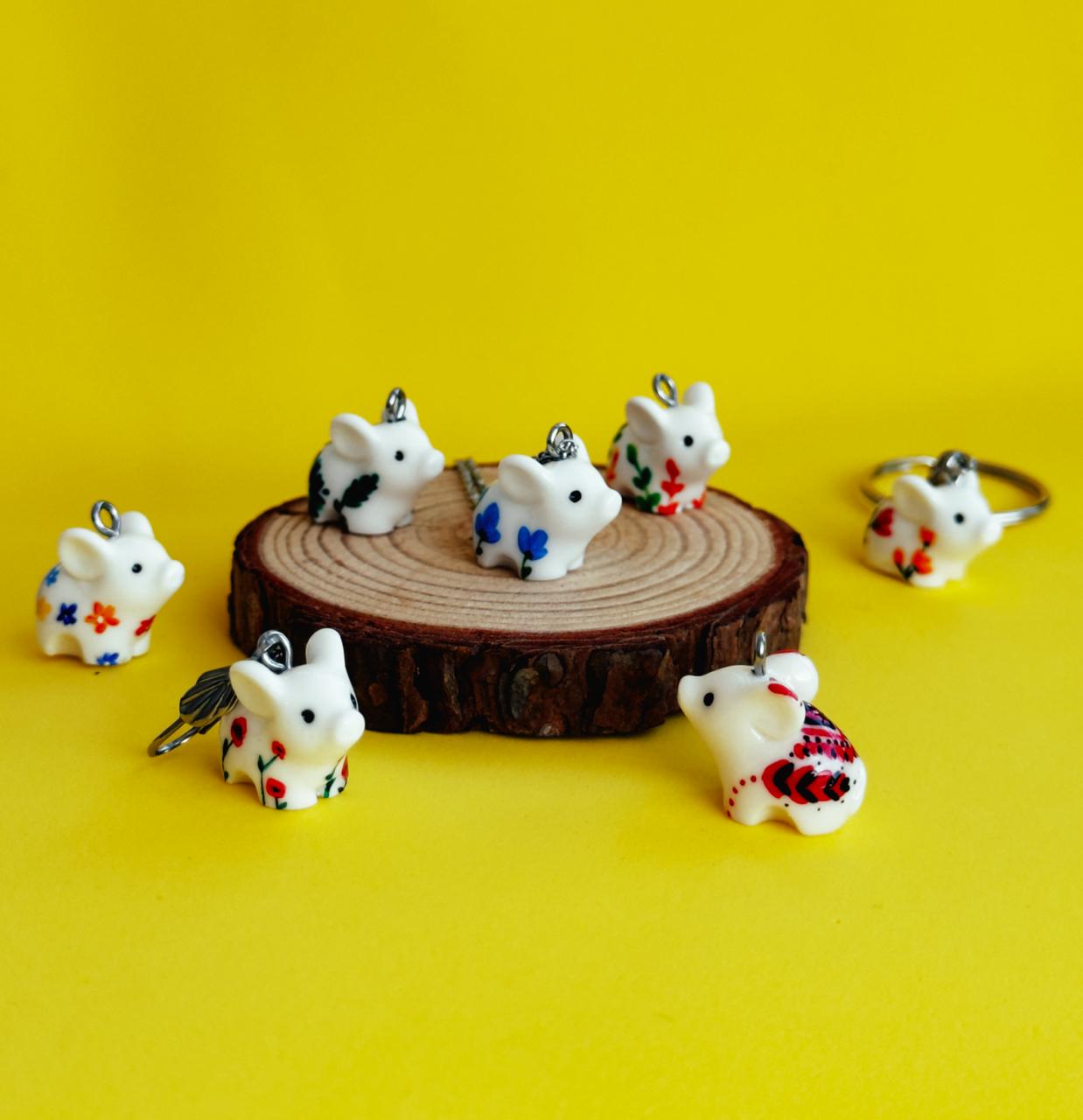 All the pendants feature a miniature piglet animal and are hand-painted.