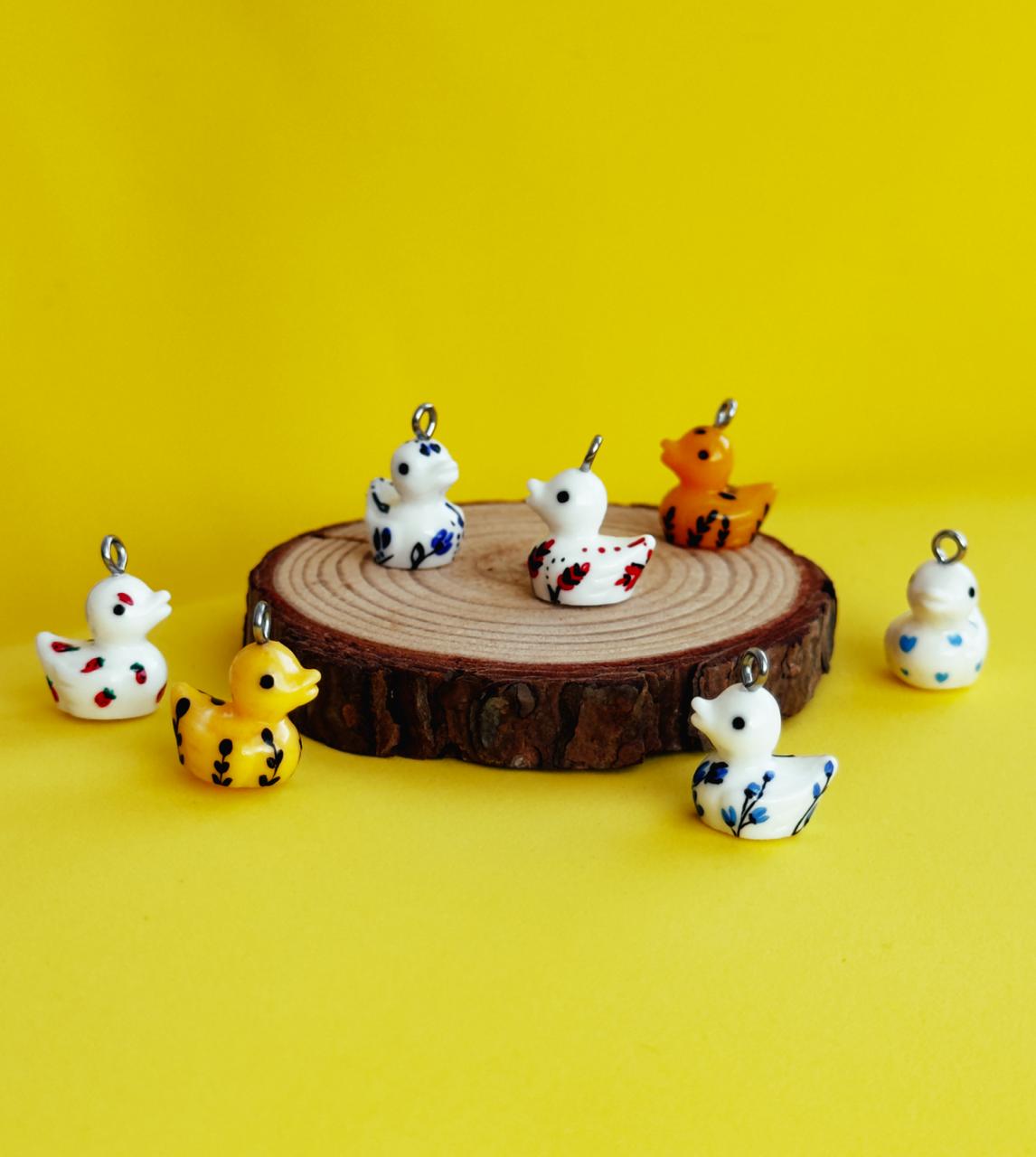 All pendants feature a miniature duck animal and hand-painted details.