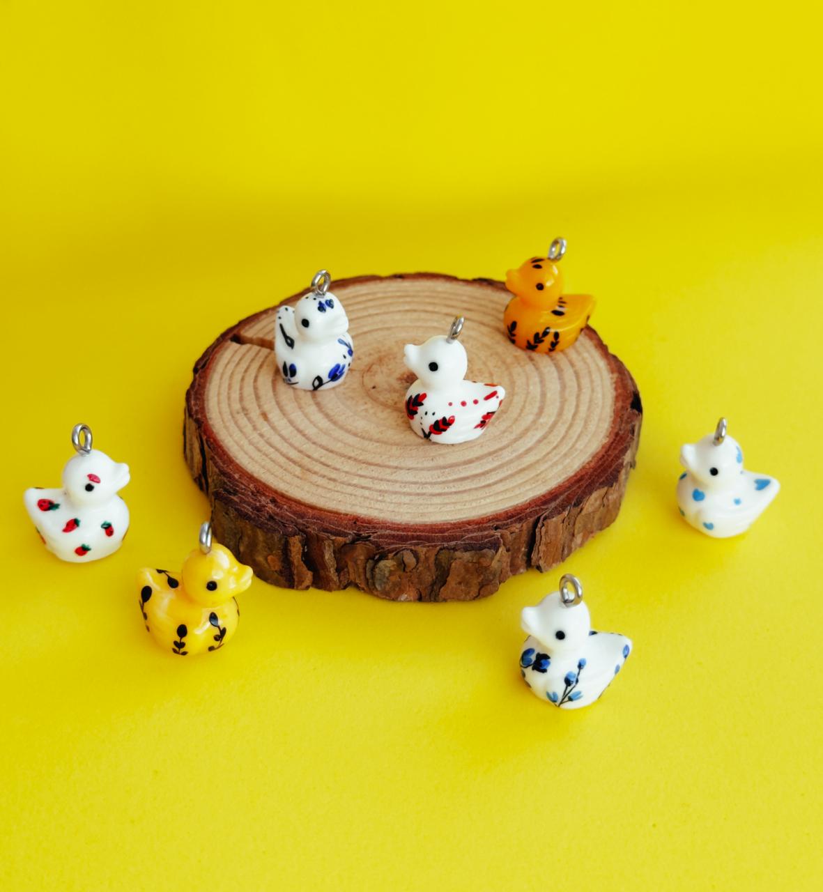 All pendants feature a miniature duck animal and hand-painted details.