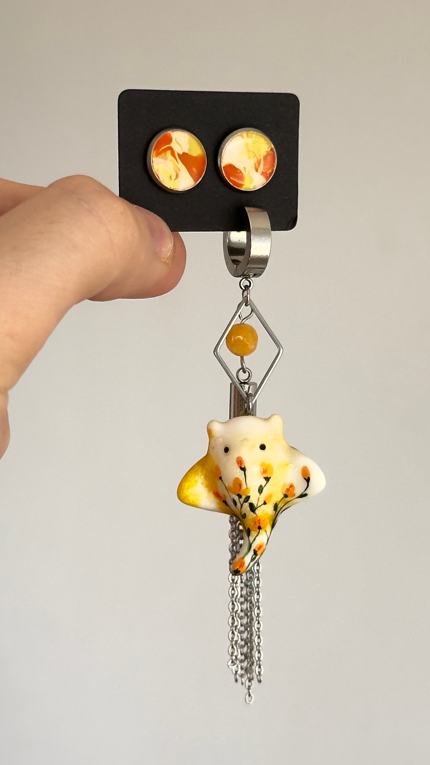 Asymmetrical earrings with a ray pendant