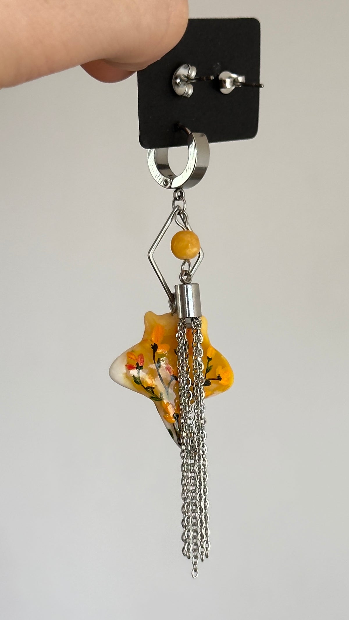 Asymmetrical earrings with a ray pendant