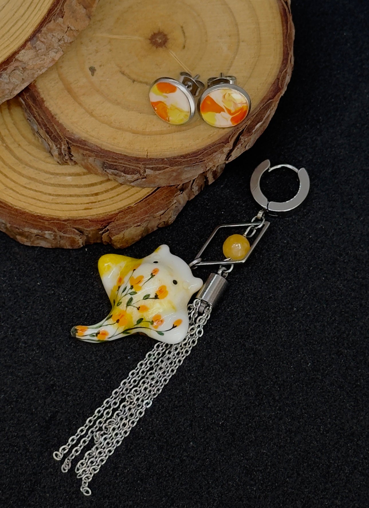 Asymmetrical earrings with a ray pendant